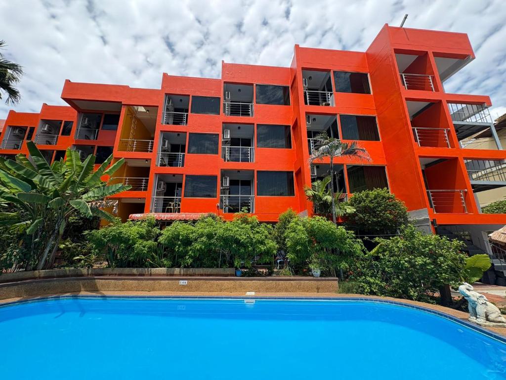 an orange building with a pool in front of it at LAY TONG BEACH HOTEL Patong in Patong Beach