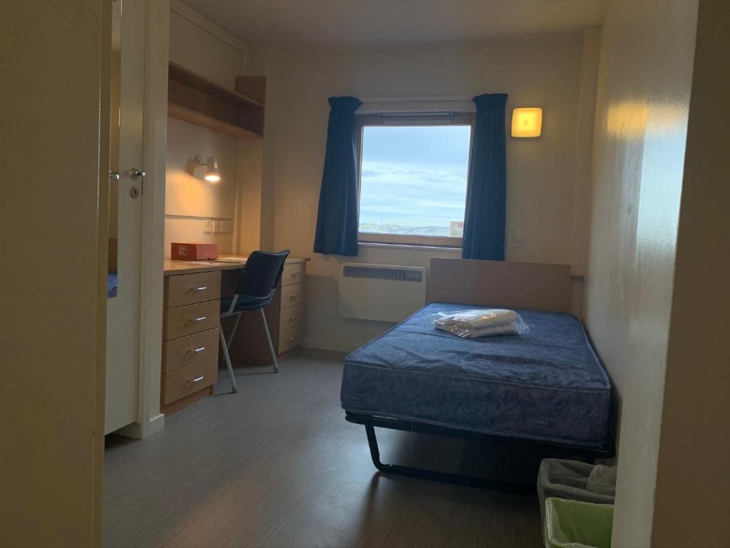 a bedroom with a bed and a desk and a window at Deanery Student Residence in Southampton