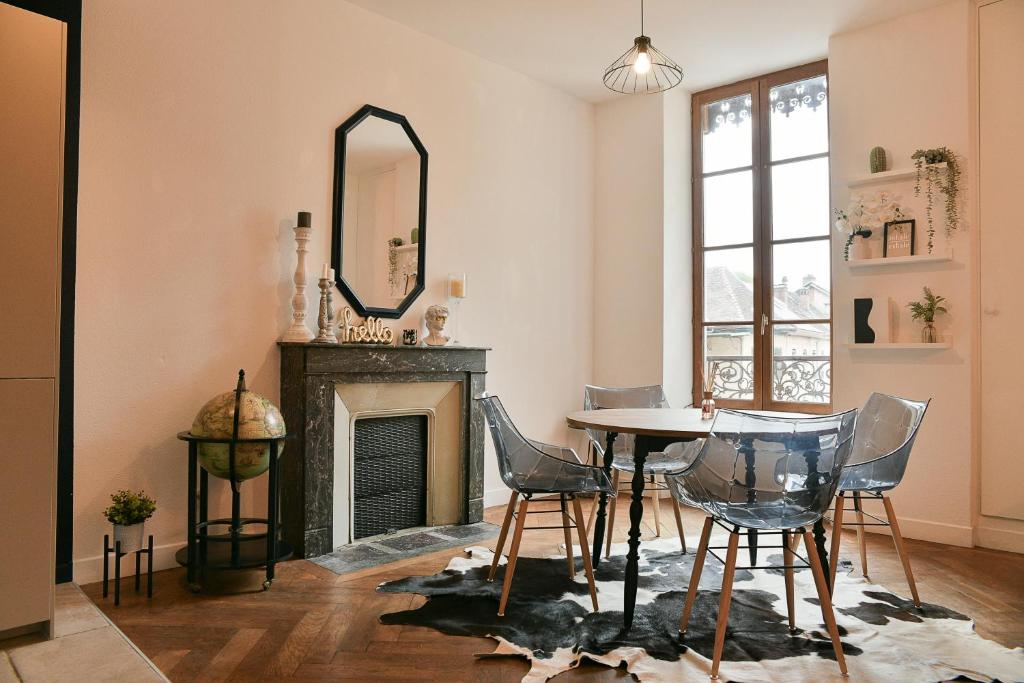 Charmant T4 Centre-ville, Lacs et Montagnes في Le Pont-de-Beauvoisin: غرفة معيشة مع طاولة وكراسي ومرآة