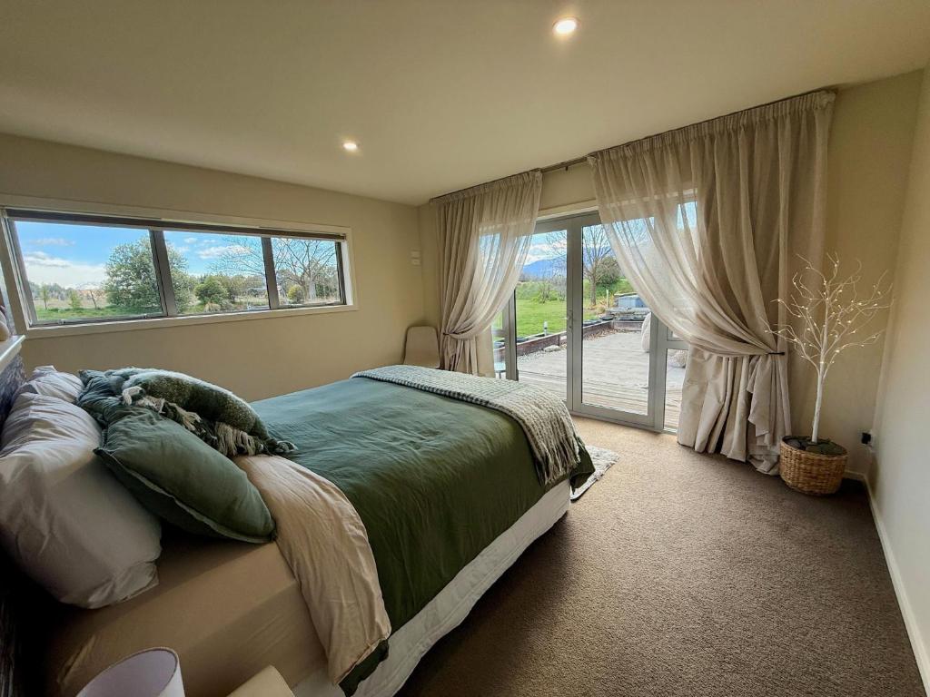 a bedroom with a bed and a large window at Relaxing Rural Retreat - Stargaze or Soak Up the Sun in Luggate