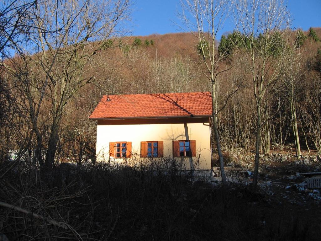 una pequeña casa blanca con techo rojo en Holiday home Lokovec 31 - Rojčeva domačija, en Čepovan