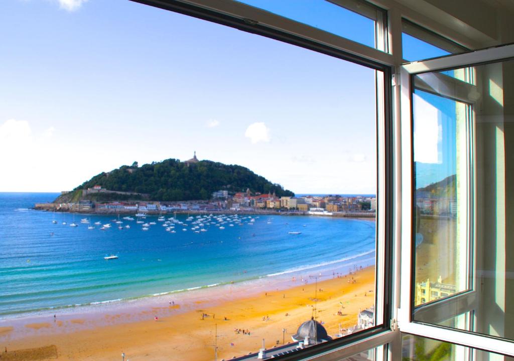 een raam met uitzicht op het strand bij Bellavista Concha Beach - SSHousing in San Sebastian