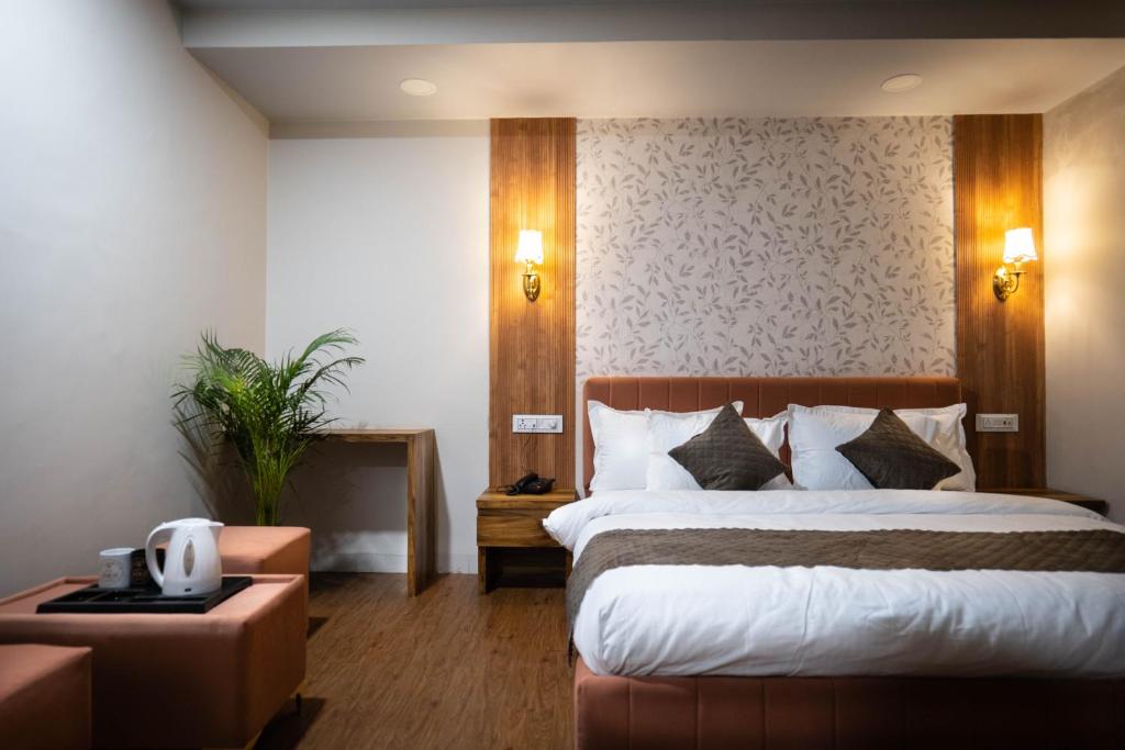 a hotel room with a bed and a table at Hotel Asilo Prime in Indore