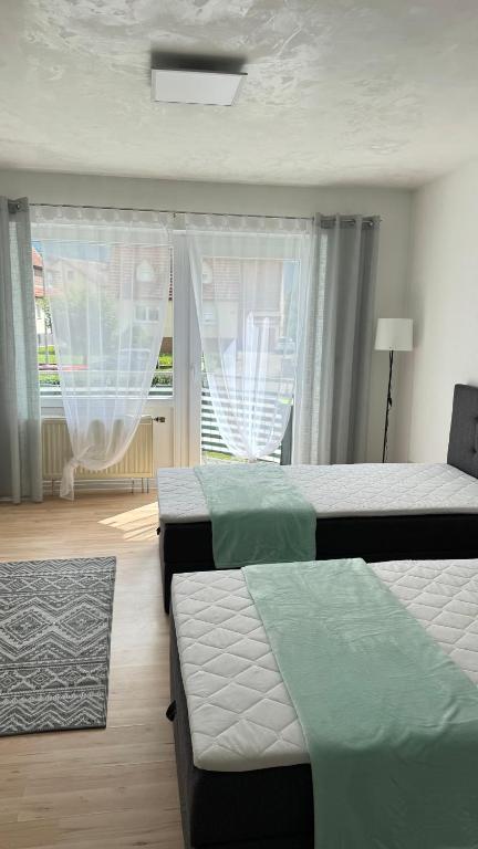 a bedroom with two beds and two windows at ZeitRaum Apartment in Balingen