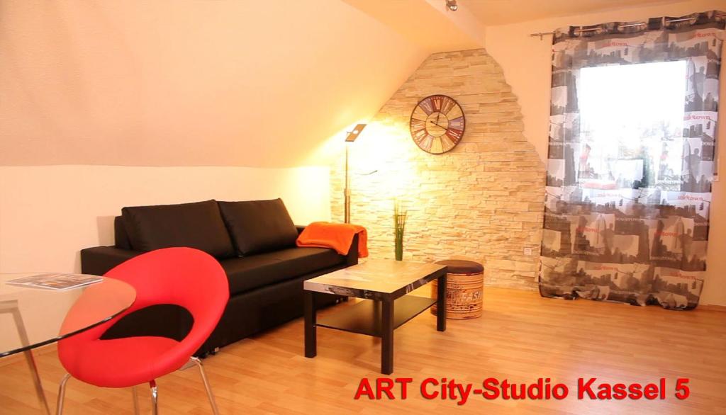 カッセルにあるArt City Studio Kassel 5のリビングルーム(黒いソファ、赤い椅子付)