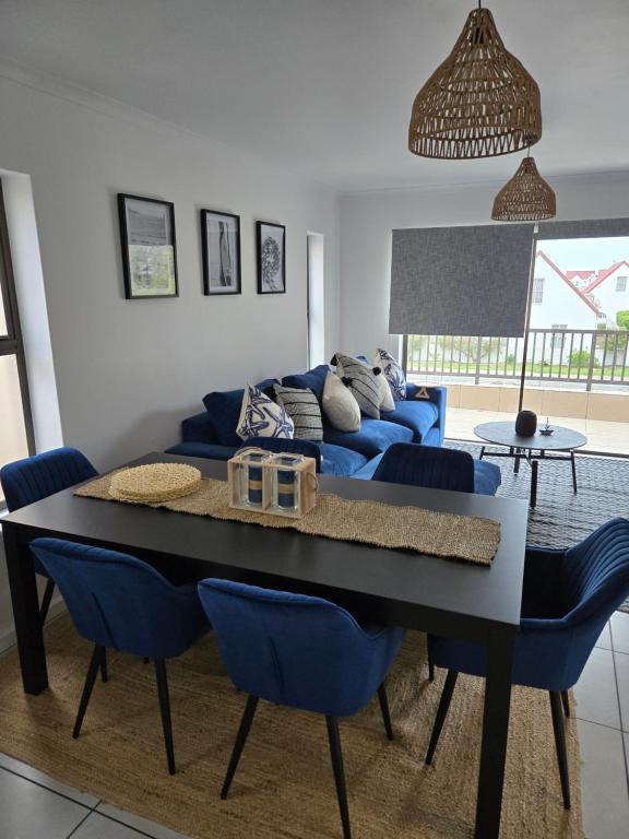 Una sala de estar con un sofá azul y sillas azules. en Coastal Cove Langebaan, en Langebaan