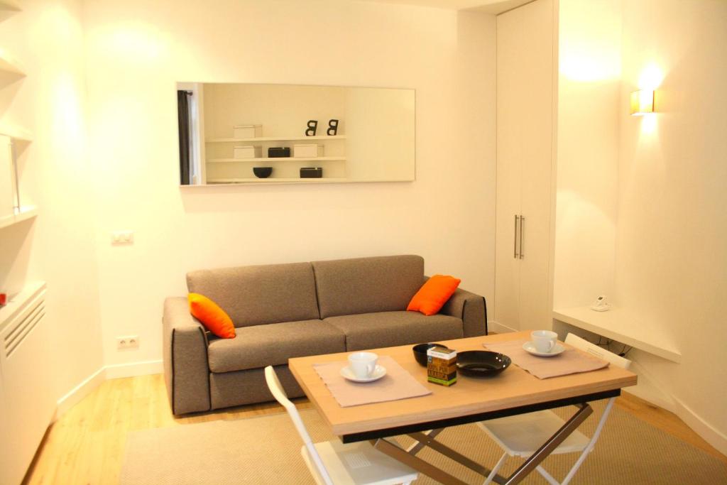 un salon avec un canapé et une table dans l'établissement Rue d'Argenteuil VII - Palais Royal, à Paris