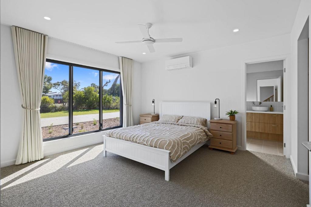 a bedroom with a bed and a large window at Wirilda Seaside Escape in Inverloch