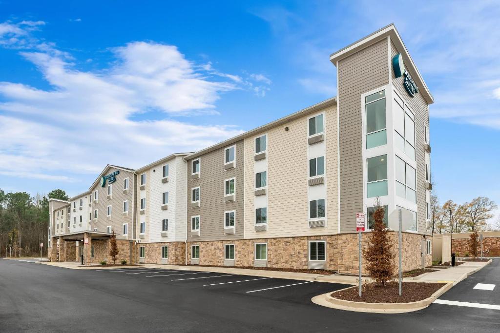 a large apartment building with a parking lot at WoodSpring Suites Richmond Airport in Henrico