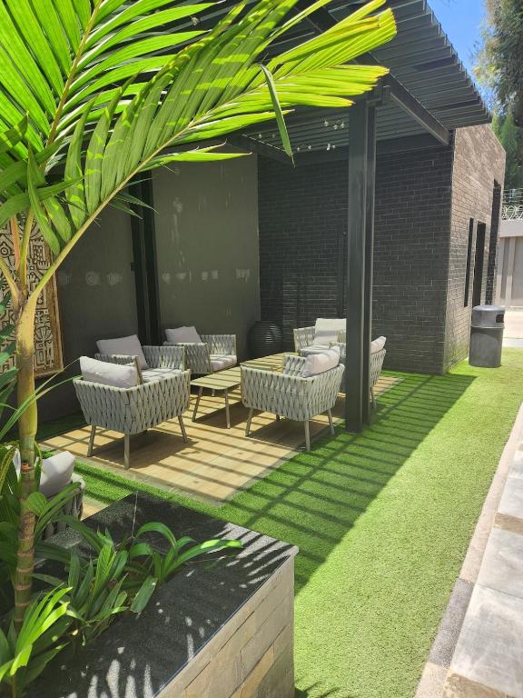a patio with chairs and a table on grass at BMJ sleek homes in Nairobi