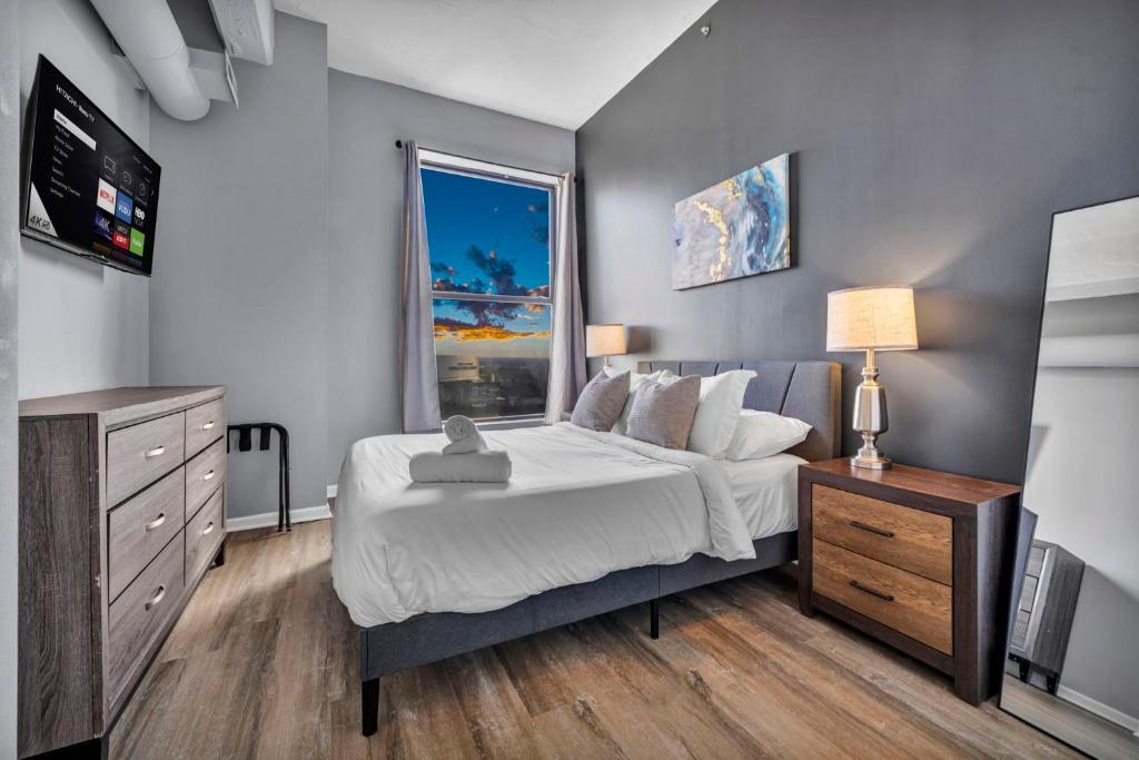 a bedroom with a bed and a tv and a window at 1BR Loft Sauna & Walk to Theater & Campus in Cleveland