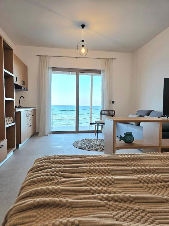 a bedroom with a bed and a view of the ocean at aelia beach living II in Kardamaina