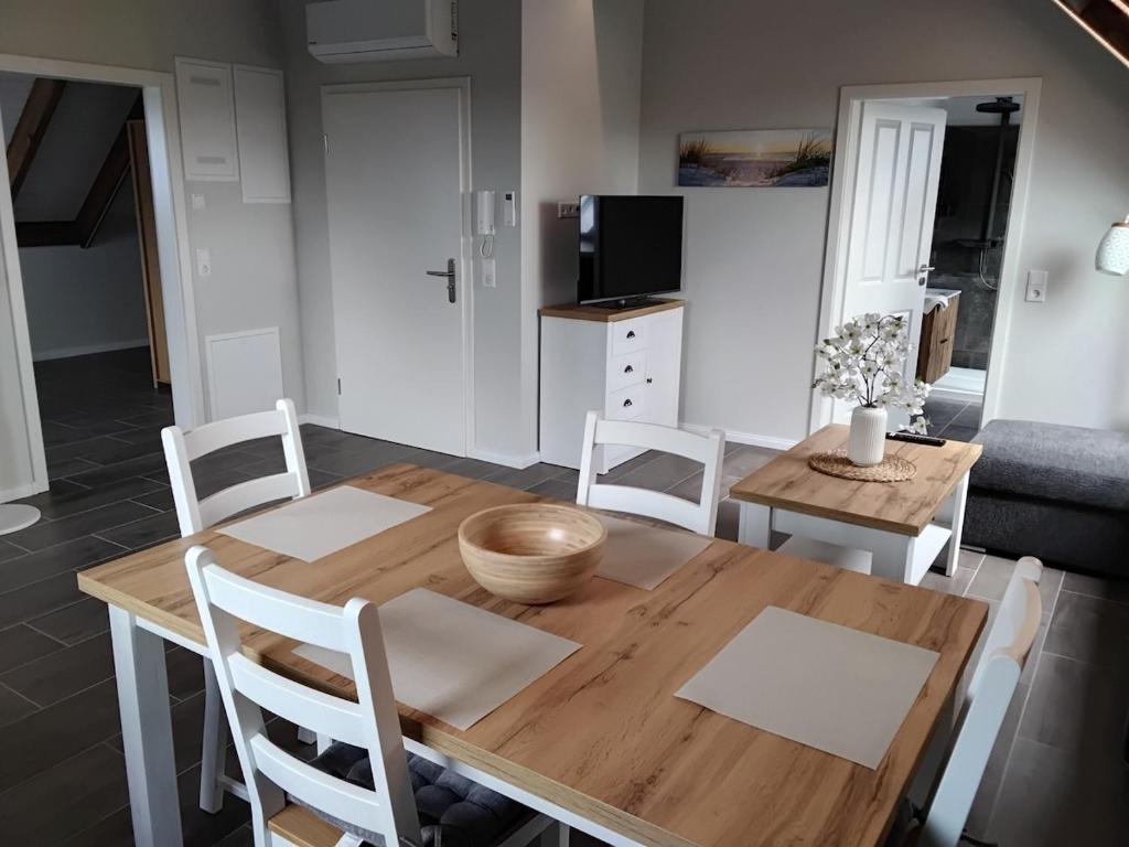 a dining room with a wooden table and chairs at Neue Welt Ferienwohnung 1 in Osteel