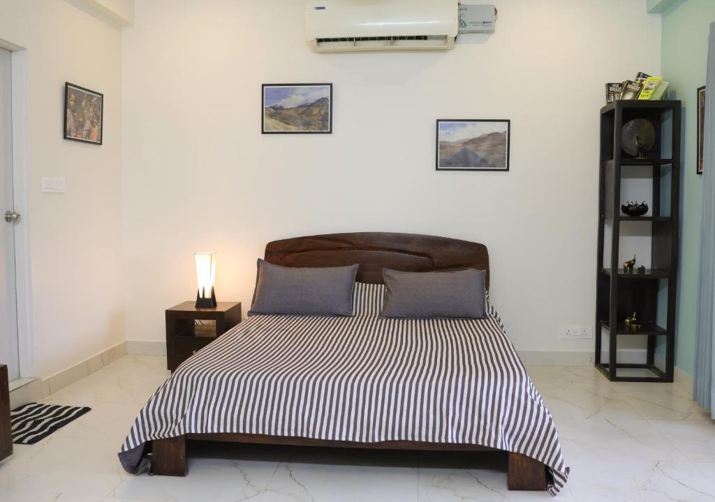 a bedroom with a bed with a black and white comforter at Shanti Niwas in Jaipur