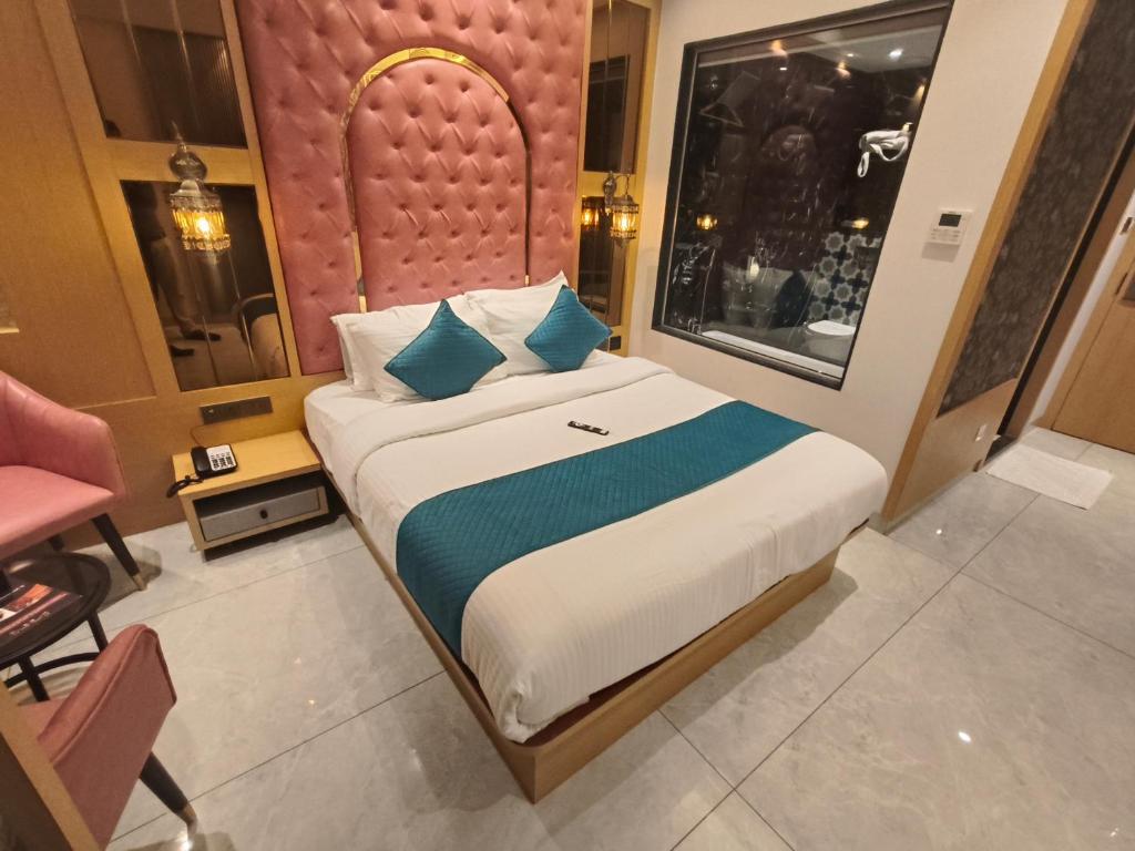 a bedroom with a large bed with blue pillows at Hotel Ocean Residency Thane West in Thane
