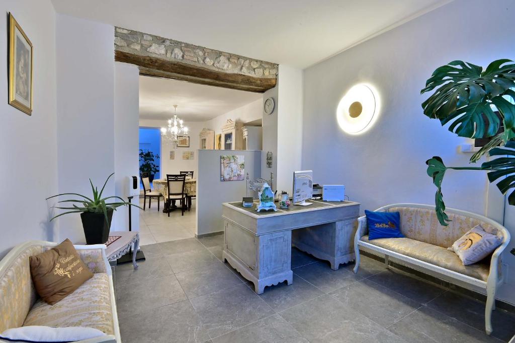 a living room with a desk and two couches at Ca' Rossa in Roe