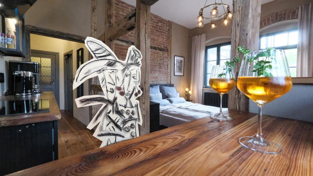 托尔高Altstadt Apartment in Torgau mit Balkon und Kunstgarten的一间房间,配有一张桌子和两杯葡萄酒