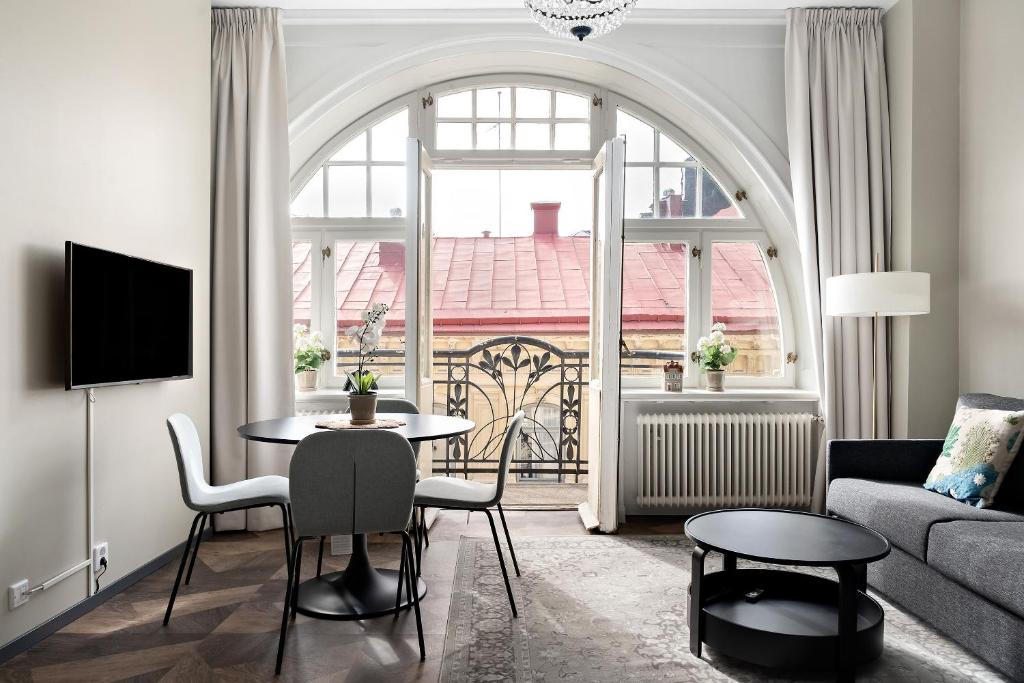 a living room with a couch and a table with chairs at Stay Inn Apartments in Vasastan in Stockholm