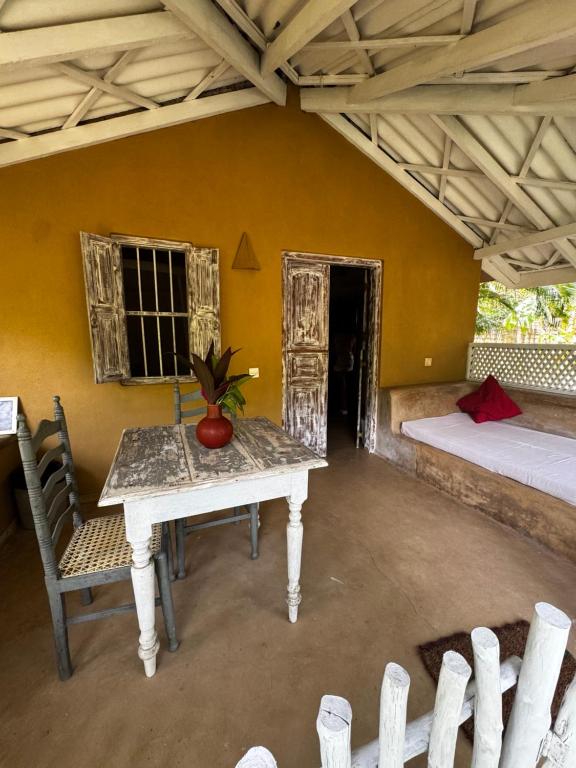 een kamer met een tafel en stoelen en een bed bij FIVE in Tangalle