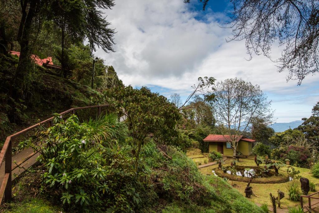 een huis aan de zijkant van een heuvel met bomen bij Paraíso Quetzal Lodge in Tres de Junio