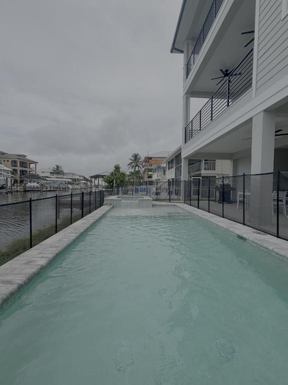 a large pool of water next to a building at 141 Brand New Luxury 6BR 6BA Build with Heated Pool! home in Fort Myers Beach