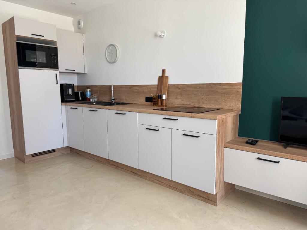 a kitchen with white cabinets and a counter top at L'Escale de l'Hirondelle in Rehaincourt
