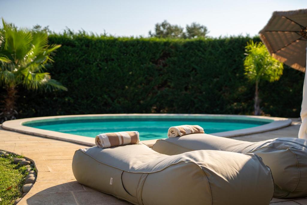 Una piscina con una cama inflable enfrente. en Villa Letto D'Alloro - Royal Dream, en Conversano