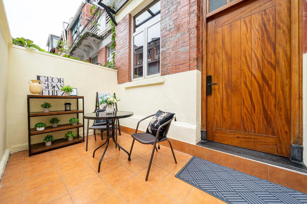 a room with a wooden door and a table and chairs at Shanghai Hills & Well-time MCM Family B&B with Terrace Near Line2 Jing'an Temple in Shanghai