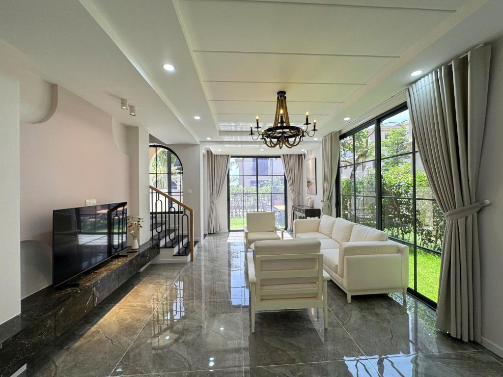 Una sala de estar con un sofá y un televisor. en Caca villa 3 bedrooms, en Phu Quoc