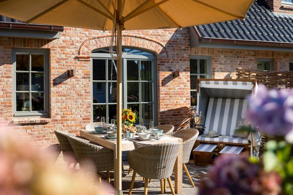 a table with an umbrella on a patio at Haus Sylter Schönheit in Westerland