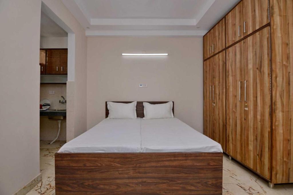 a bedroom with a large bed and a wooden cabinet at Collection O DLF Cyberhub Gurugram in Gurgaon