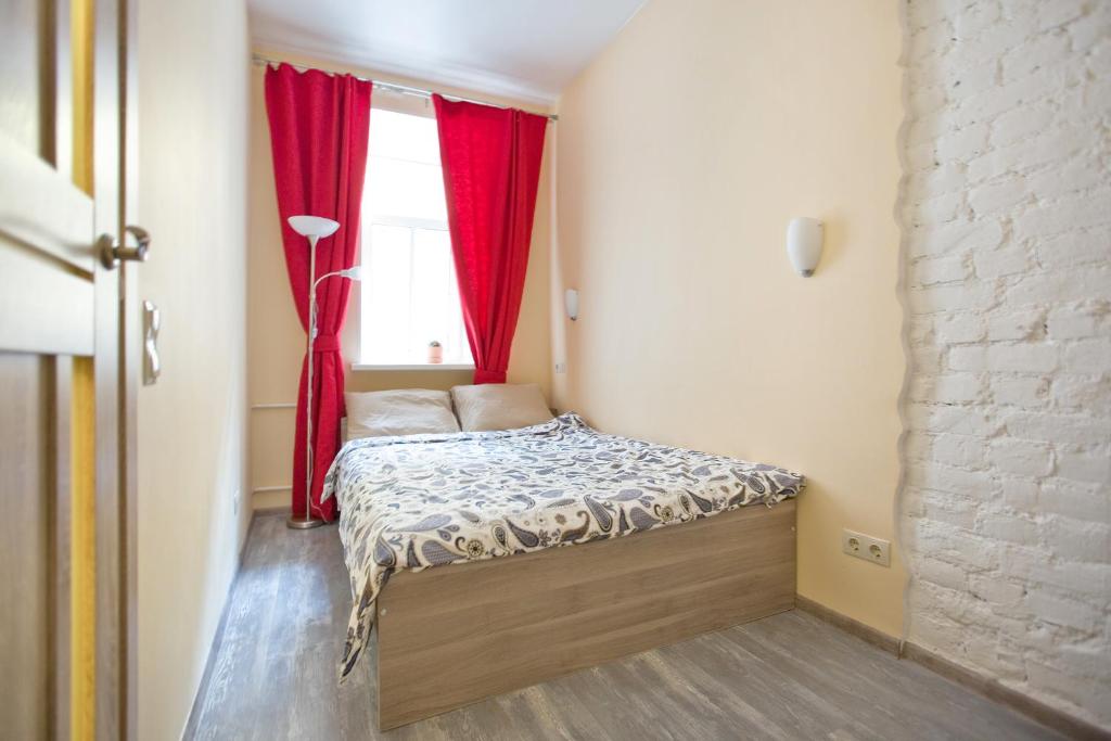 a small bedroom with a bed and a window at Apartment Next to Sennaya square in Saint Petersburg