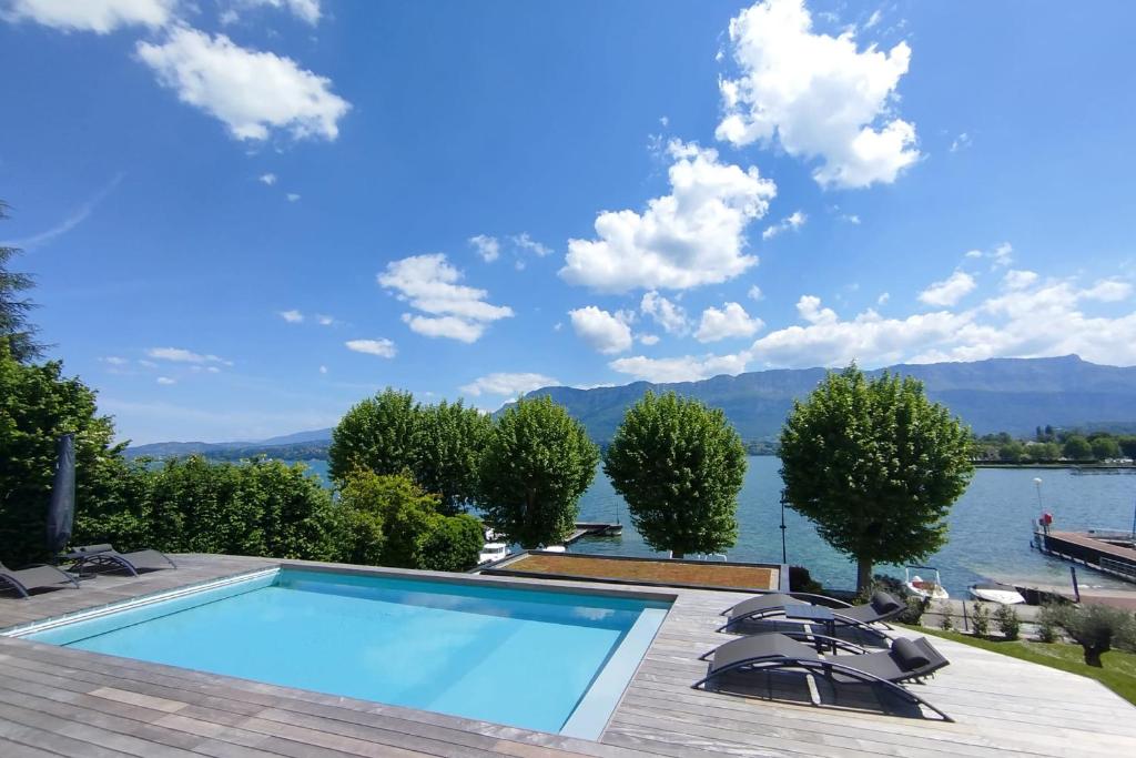 CatonにあるVilla d'exception Piscine vue et accès lac directの湖と山の景色を望むスイミングプール