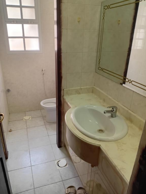 un baño con lavabo e inodoro en Ariyan, en Mascate