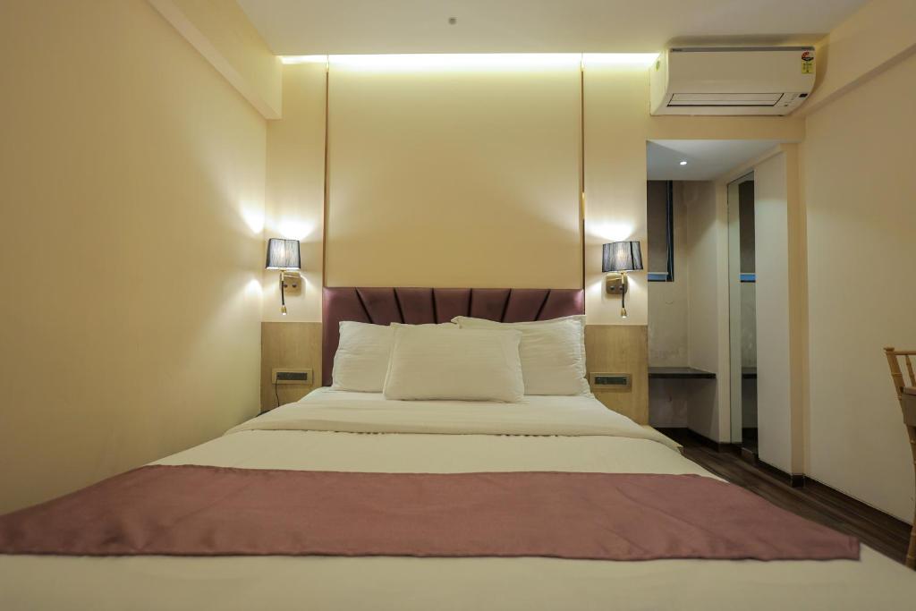 1 dormitorio con 1 cama grande con 2 luces. en Vishal Hall, en Bombay