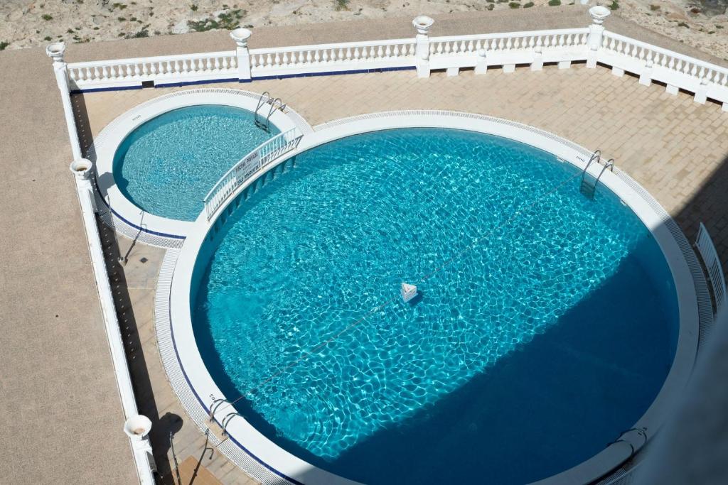 una vista aérea de dos piscinas de agua en Apartamentos Dominique, en La Manga del Mar Menor