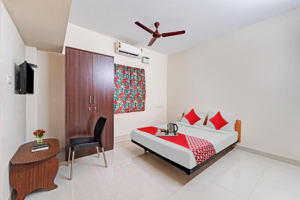 钦奈HOTEL O J2 SERVICE APARTMENT的一间卧室，配有一张床、一张桌子和一把椅子