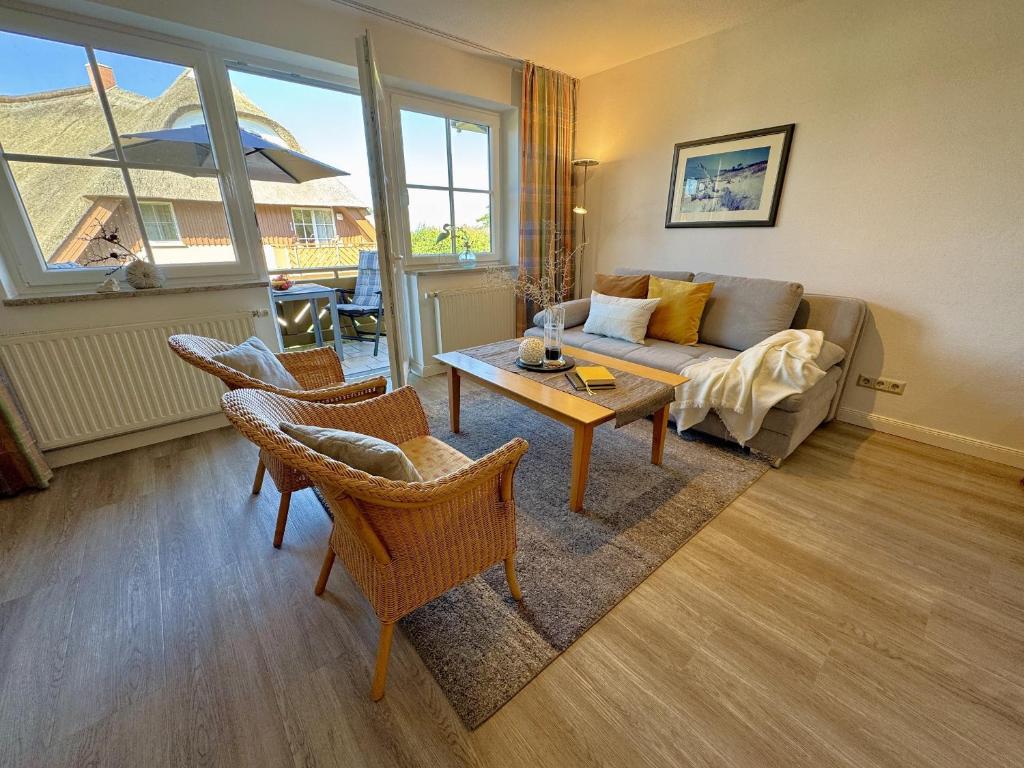 a living room with a couch and a table at Birkenhof App 44 in Wustrow