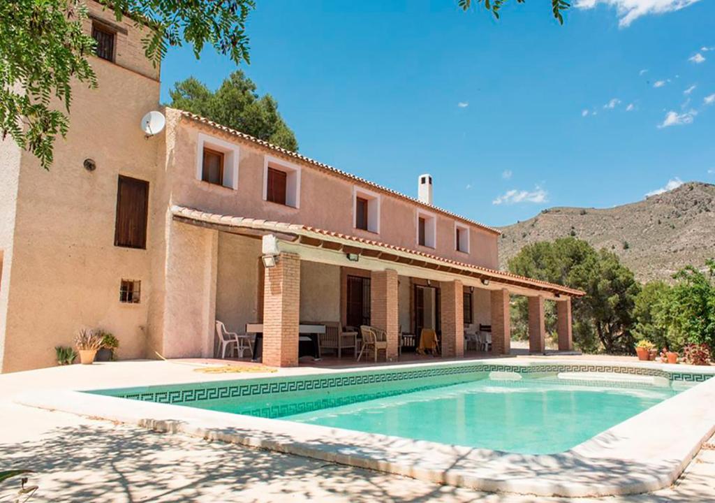 a villa with a swimming pool in front of a building at Villa Montesa in Elche de la Sierra