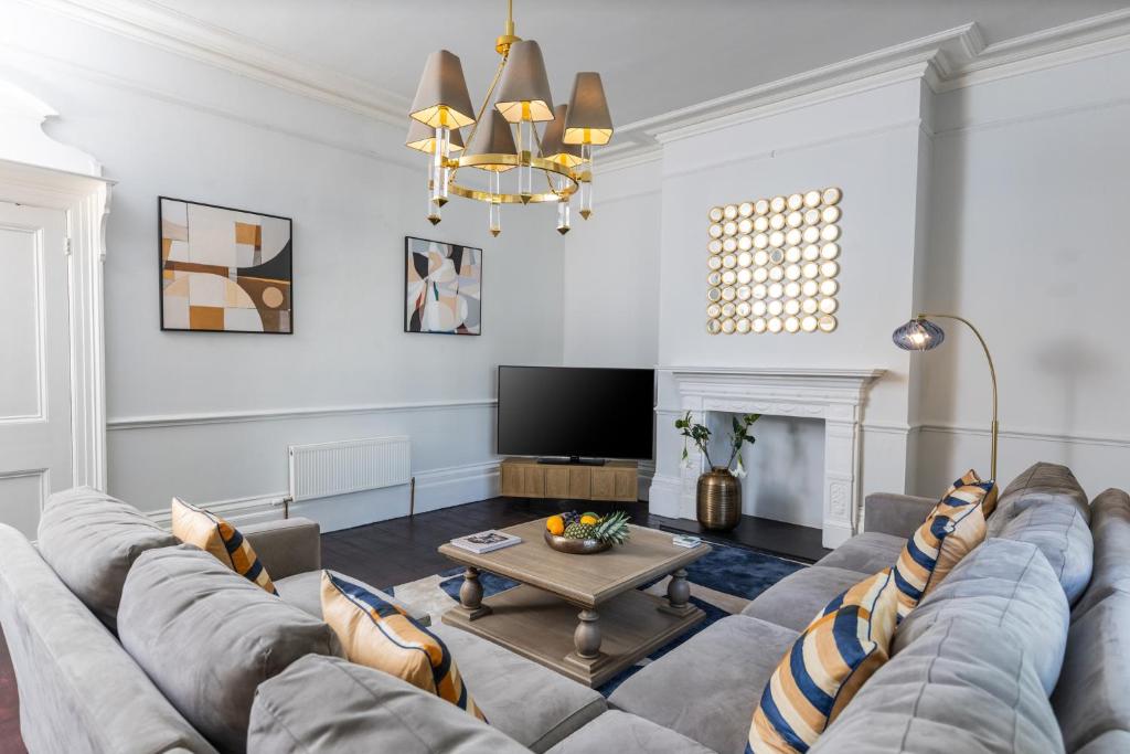 a living room with a couch and a tv at 15 Pittville Lawn in Cheltenham