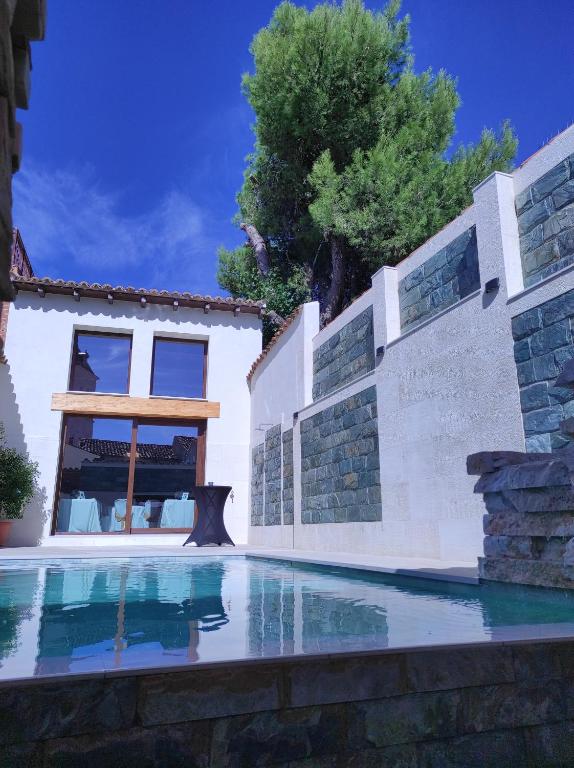 a swimming pool in front of a house at La Encomienda de Oreja in Colmenar de Oreja