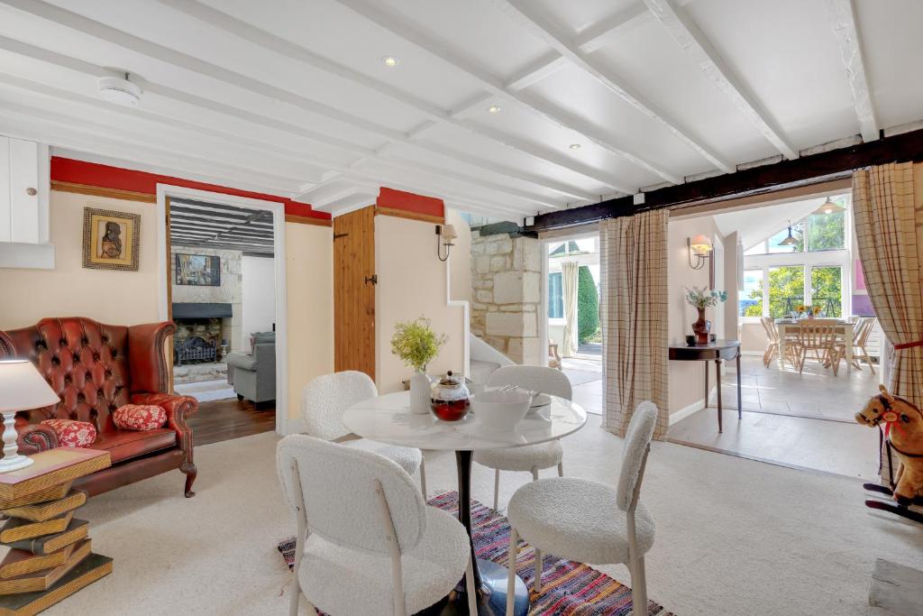 a living room with a table and chairs at Whitehall Cottage in Painswick