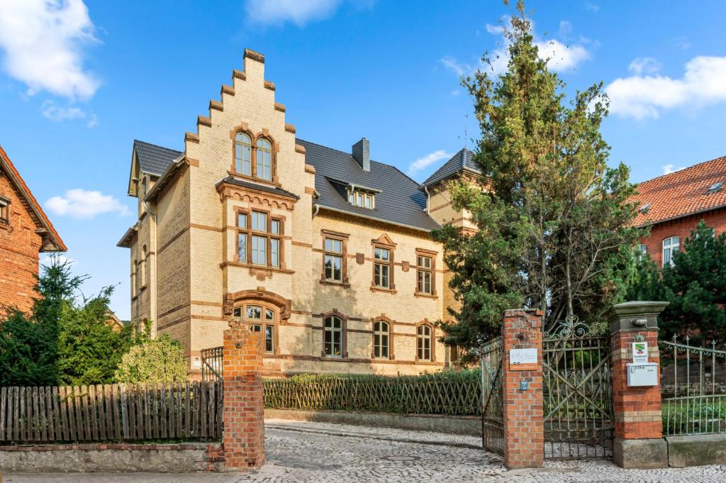an old house with a fence in front of it at Villa Bianca am Huy in Dingelstedt