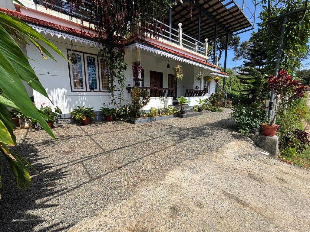 une maison avec une allée de gravier devant elle dans l'établissement Homestay INN Munnar, à Anachal