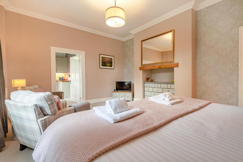 a bedroom with a bed and a living room at Bethby Beck Apartment Keswick at The Lairbeck in Keswick