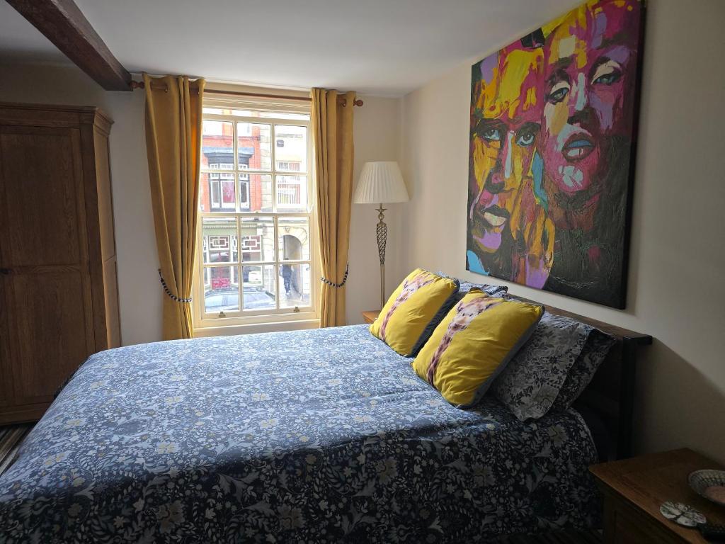 a bedroom with a bed with a painting on the wall at Unicorn Hotel Llanidloes in Llanidloes