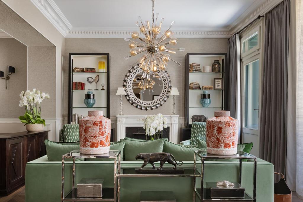 a living room with a green couch and a chandelier at Hotel Monge in Paris