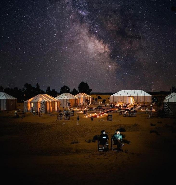 two people sitting in chairs under the milky way at night at Merzouga Marvelous Camp in Merzouga