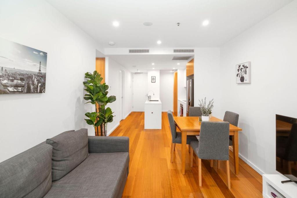 ein Wohnzimmer mit Sofa und Tisch in der Unterkunft Modern 2Br Ground Level City Retreat with Parking in Braddon