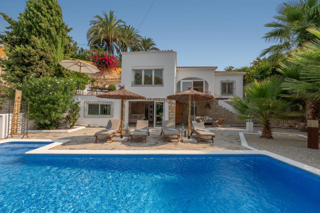 a villa with a swimming pool and a house at Casa Cobalto, Sea view, Mediterranean, Sea 700meters, 4 Bedrooms in Benissa